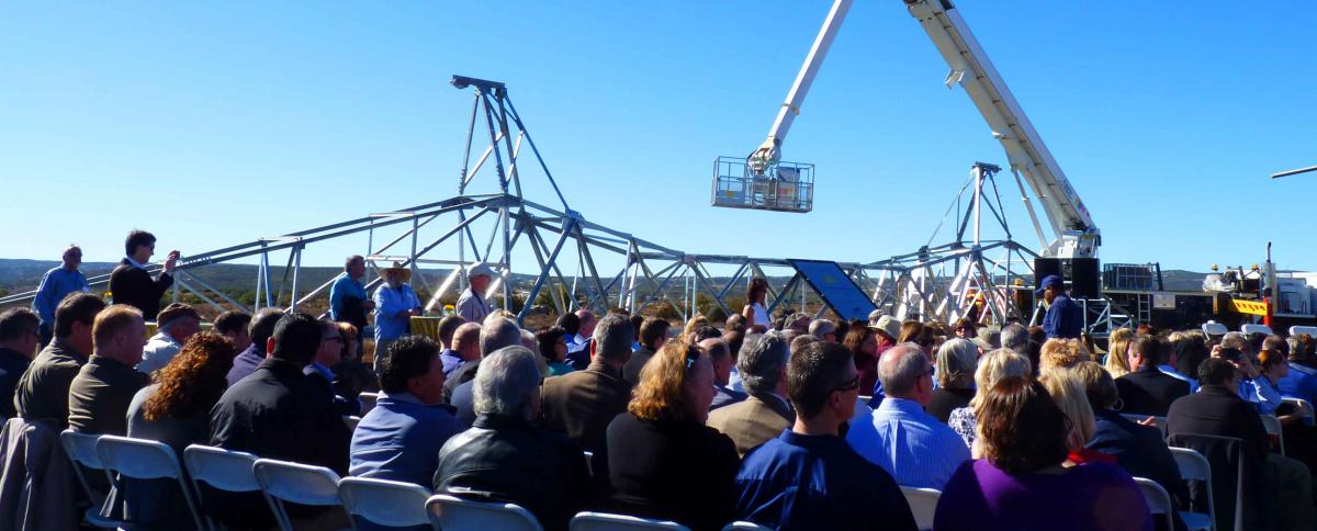 Top of just one massive-scale tower dwarfs crowd; each will stand hundreds of feet tall through scenic and wilderness areas.